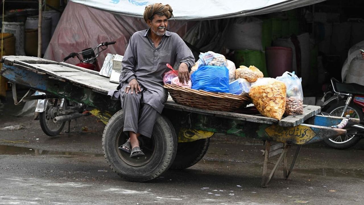 A vendor selling chips waits for customers at a market in Rawalpindi. Credit: AFP Photo