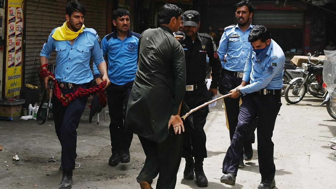Pakistan police hits a detained PTI worker. Credit: AFP Photo