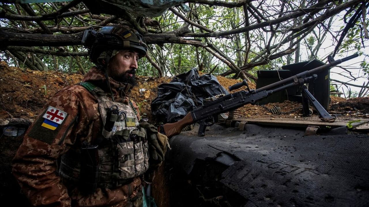 A Ukrainian serviceman observes an area from a trench at a position near the frontline town of Bakhmut, amid Russia's attack on Ukraine. Credit: Reuters Photo