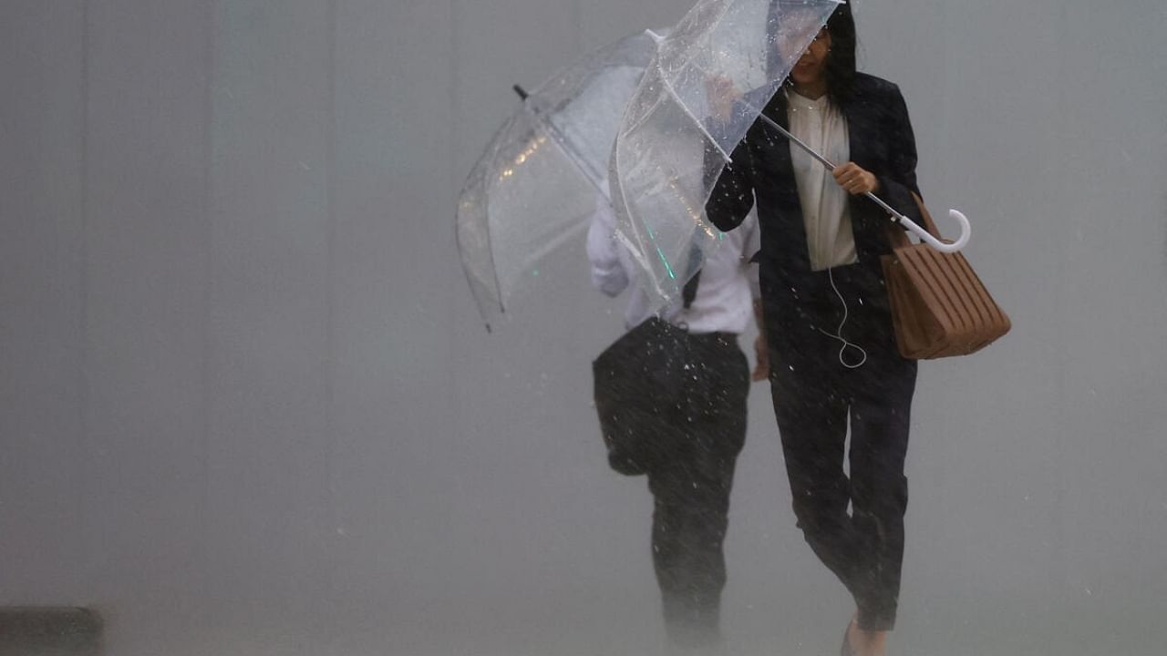 Pedestrians holding umbrellas make their way in the heavy rain in Tokyo. Credit: Reuters Photo