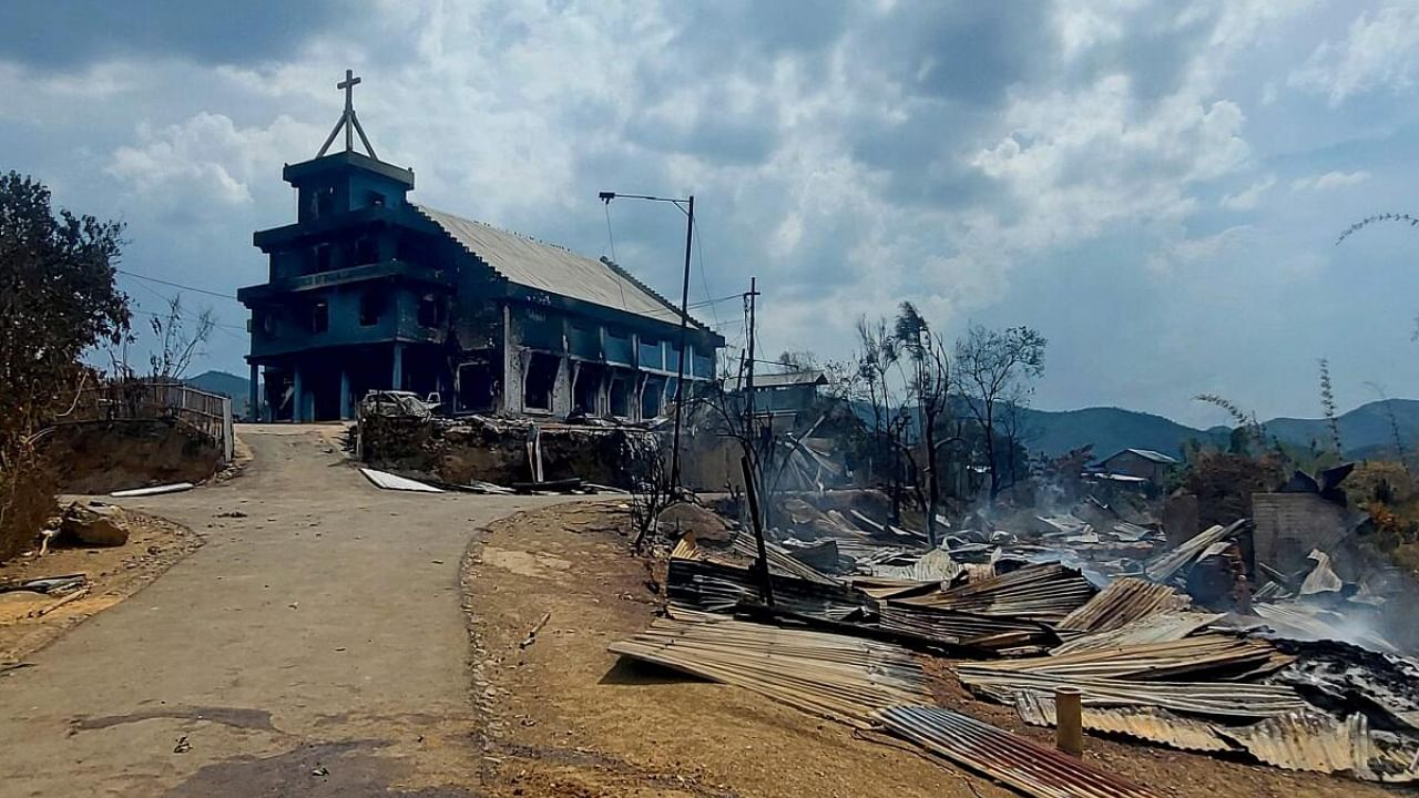 The remains of a burnt church (L) and houses (R) are seen in Manipur. Credit: AFP Photo
