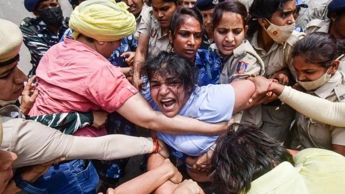 Sakshi Malik, one of the trio spearheading the wrestlers' protest, being detained by Delhi police during their march to the new Parliament building on May 28. Credit: IANS Photo