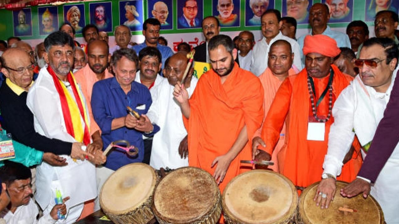K'taka deputy CM D K Shivakumar, former PM H D Deve Gowda, writer Baraguru Ramachandrappa and JD(S) leader C M Ibrahim join a few pontiffs in beating the drums to mark the inauguration of a protest against the revision of textbooks by the Rohith Chakratirtha committee in Bengaluru last year. Credit: DH File Photo