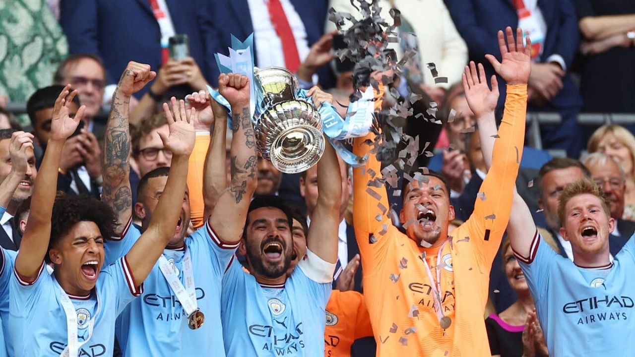 Manchester City's Ilkay Gundogan lifts the trophy as he celebrates with teammates after winning the FA Cup. Credit: Reuters Photo