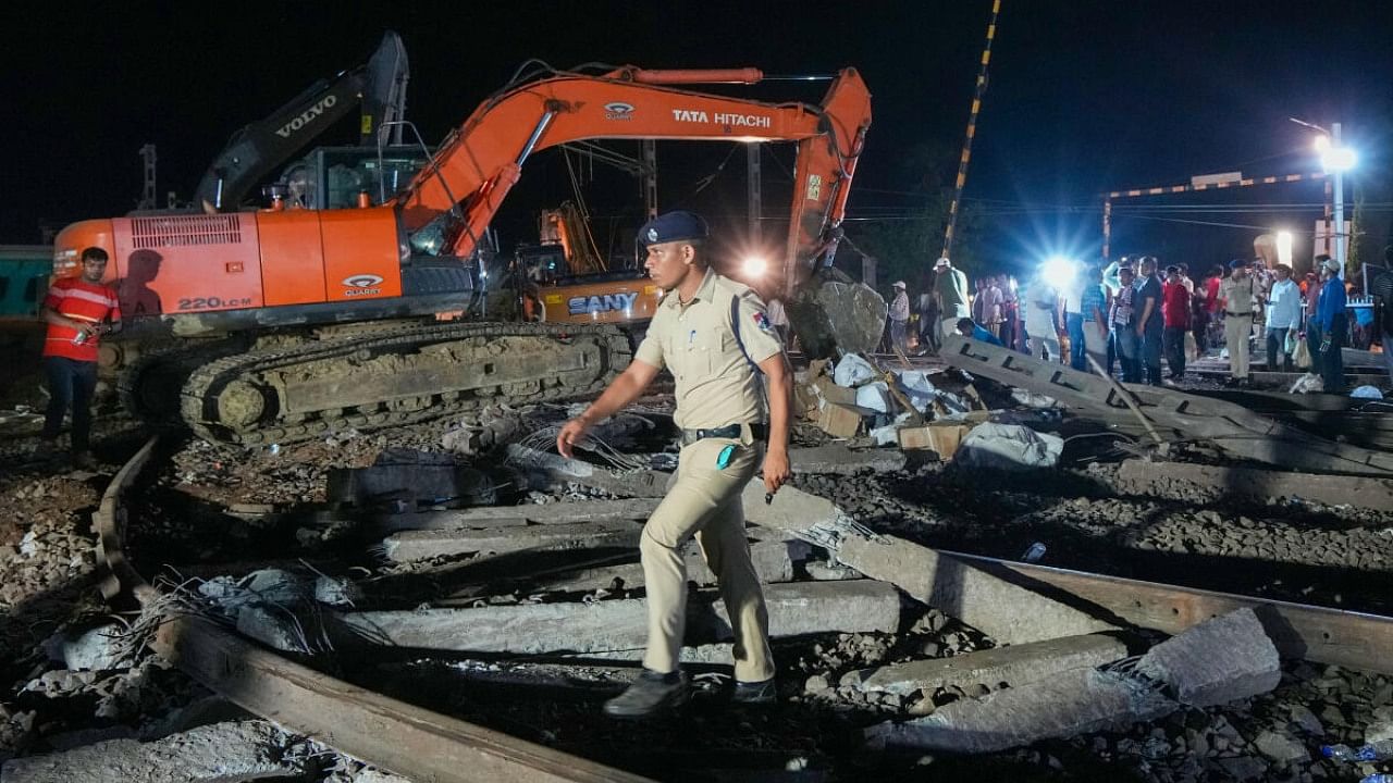  A police pesonnel crosses the mangled railway tracks during a rescue and search operation after the triple train mishap that claimed at least 261 people and left over 900 injured, in Balasore district, Odisha, Saturday, June 3, 2023. Credit: PTI Photo