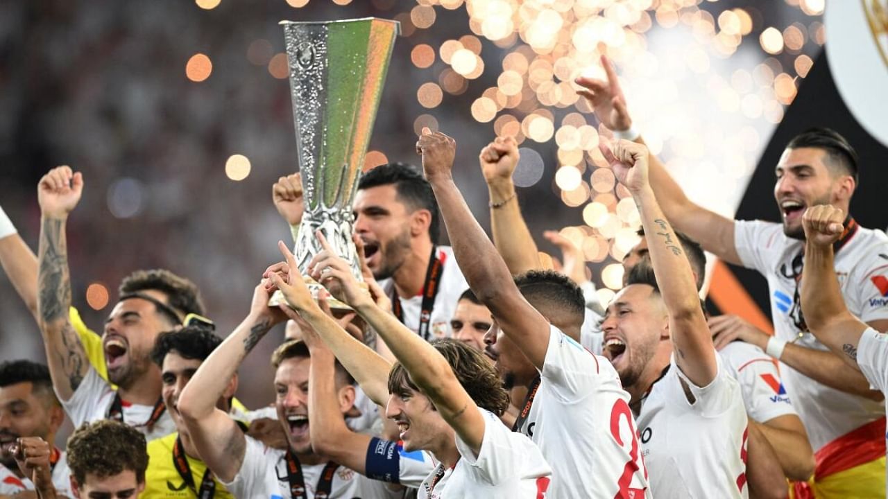 Sevilla's Ivan Rakitic and Jesus Navas lift the trophy as they celebrate with teammates after winning the Europa League. Credit: Reuters Photo