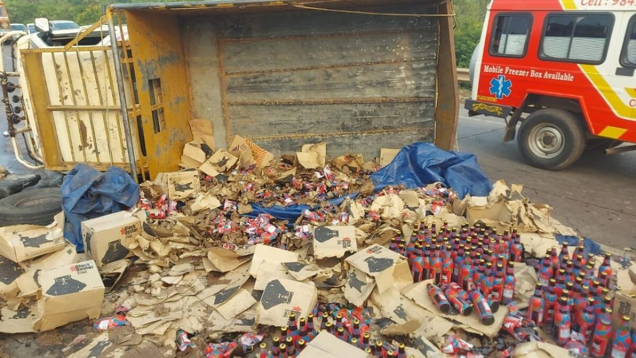 Liquor bottles looted after truck overturns in Andhra. Credit: IANS Photo