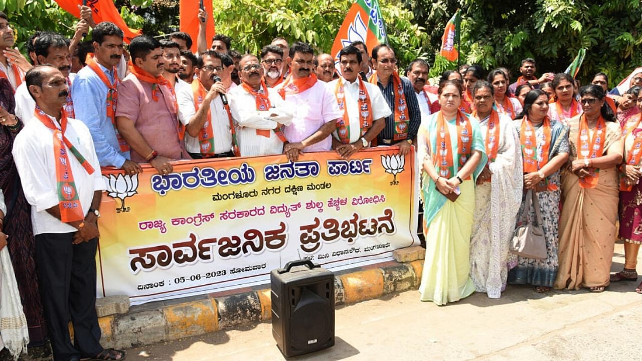 BJP members stage a protest against the state government condemning the hike in power tariff, in Mangaluru on Monday. Credit: DH Photo