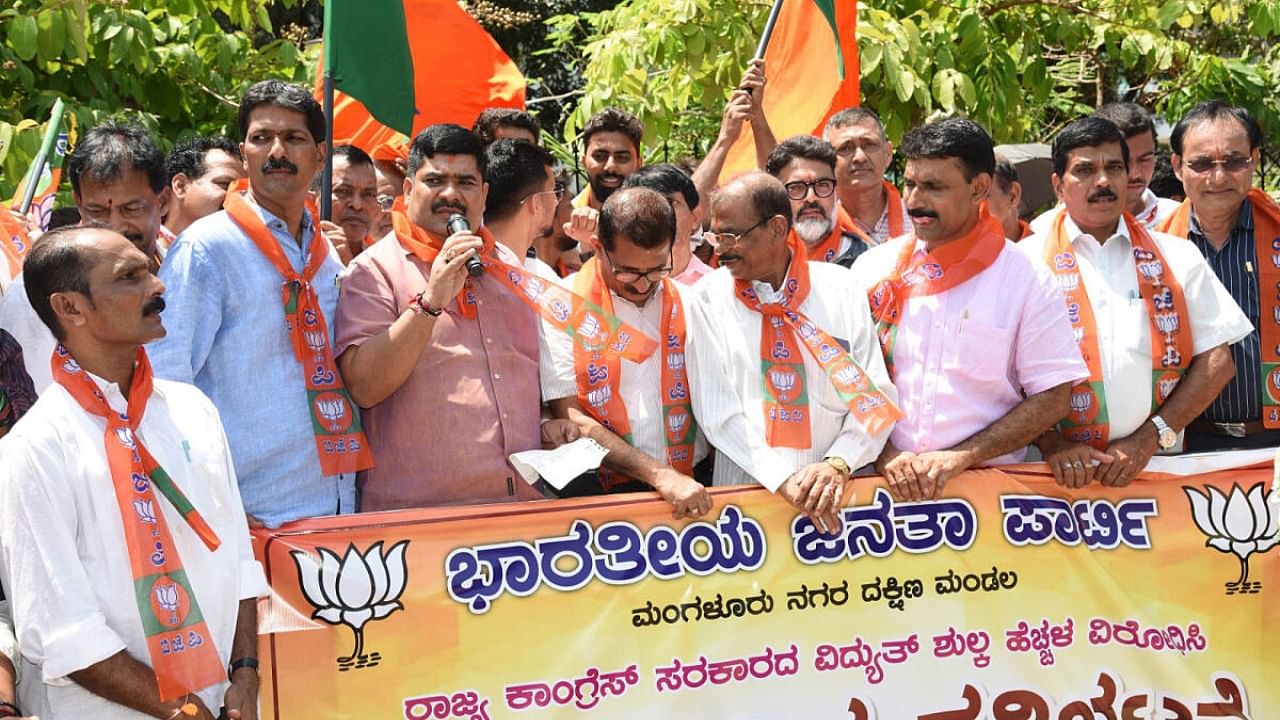 Mangalore City South MLA Vedavyasa Kamath addresses the party workers during a protest against the hike in power tariff, in front of Clock Tower in Mangaluru. DH photo