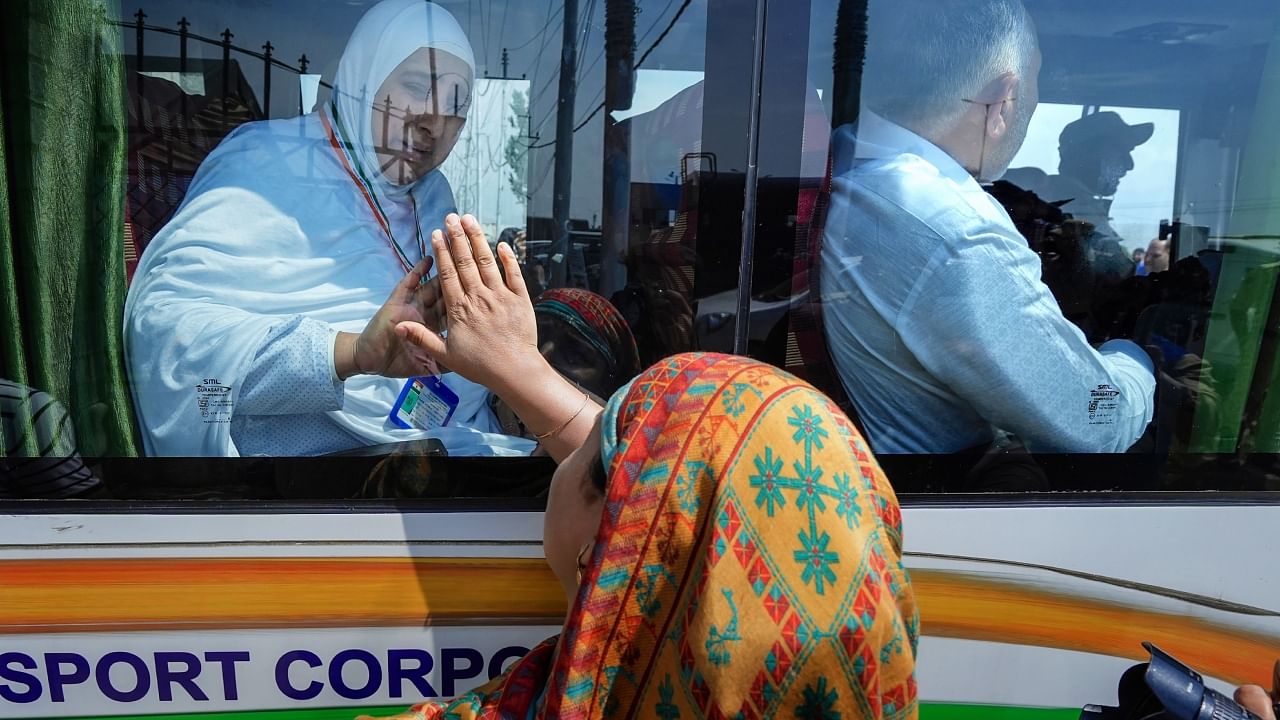 A Haj pilgrim waves to her relative as she leaves for the annual pilgrimage to Mecca. Credit: PTI Photo