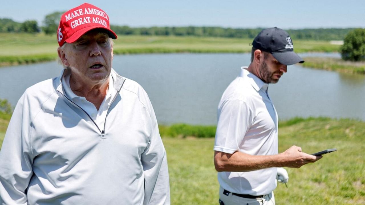 Former US President Donald Trump talks with reporters as he and his son Eric Trump participate in the Pro-Am tournament ahead of the LIV Golf Invitational at the Trump National Golf Club in Sterling, Virginia, US. Credit: Reuters Photo