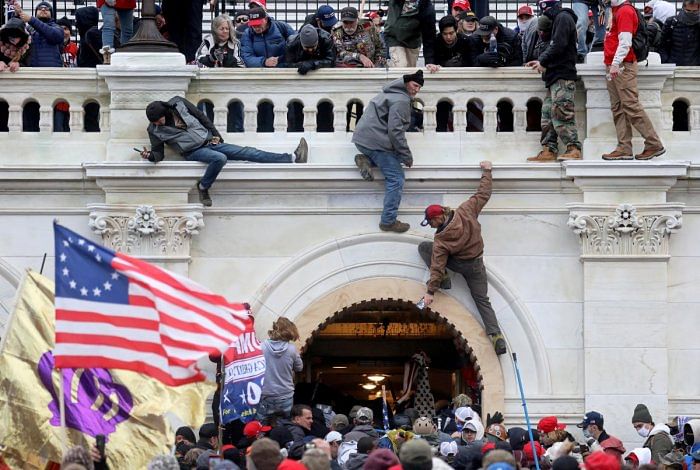 A mob of supporters of US President Donald Trump fight with members of law enforcement at a door they broke open as they storm the US Capitol Building in Washington, US, January 6, 2021. Credit: Reuters Photo