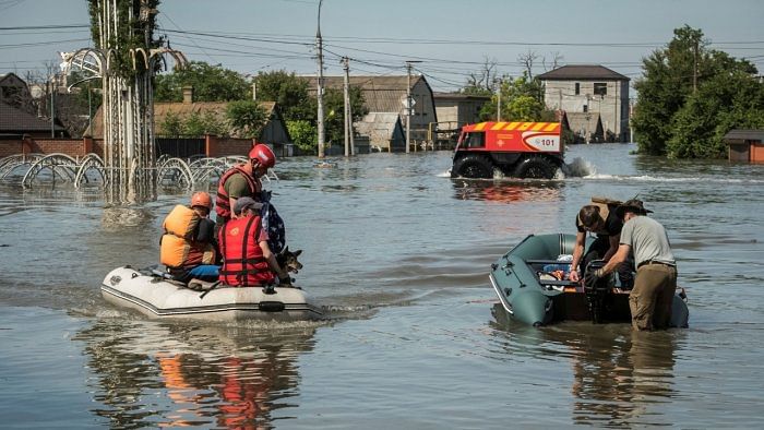 Rescuers evacuate local residents from a flooded area after the Nova Kakhovka dam breached, in Kherson. Credit: Reuters Photo