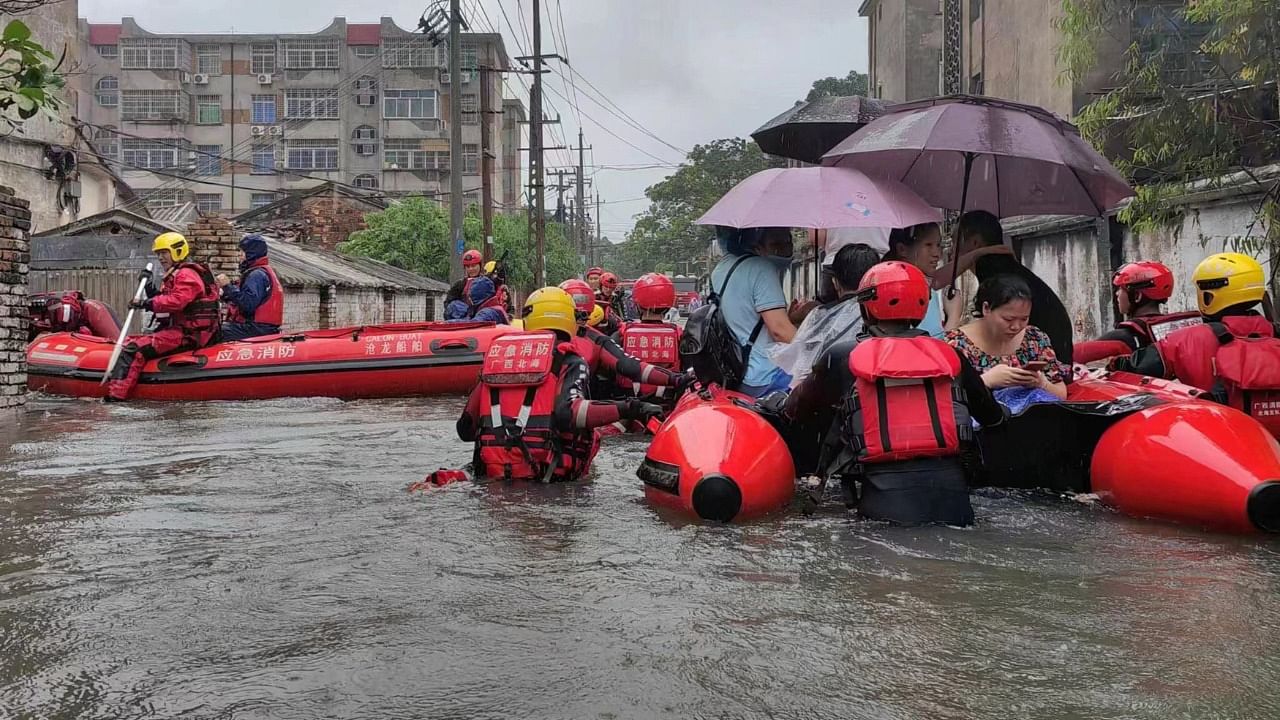 Rescue workers evacuate stranded residents on a flooded street following heavy rainfall in Beihai. Credit: cnsphoto via Reuters