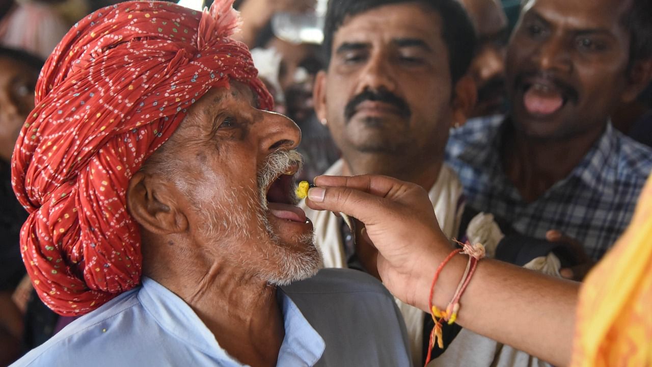 A member of the Bathini family administers traditional fish 'prasadam' to an asthma patient at the Nampally Exhibition ground in Hyderabad. Credit: PTI Photo