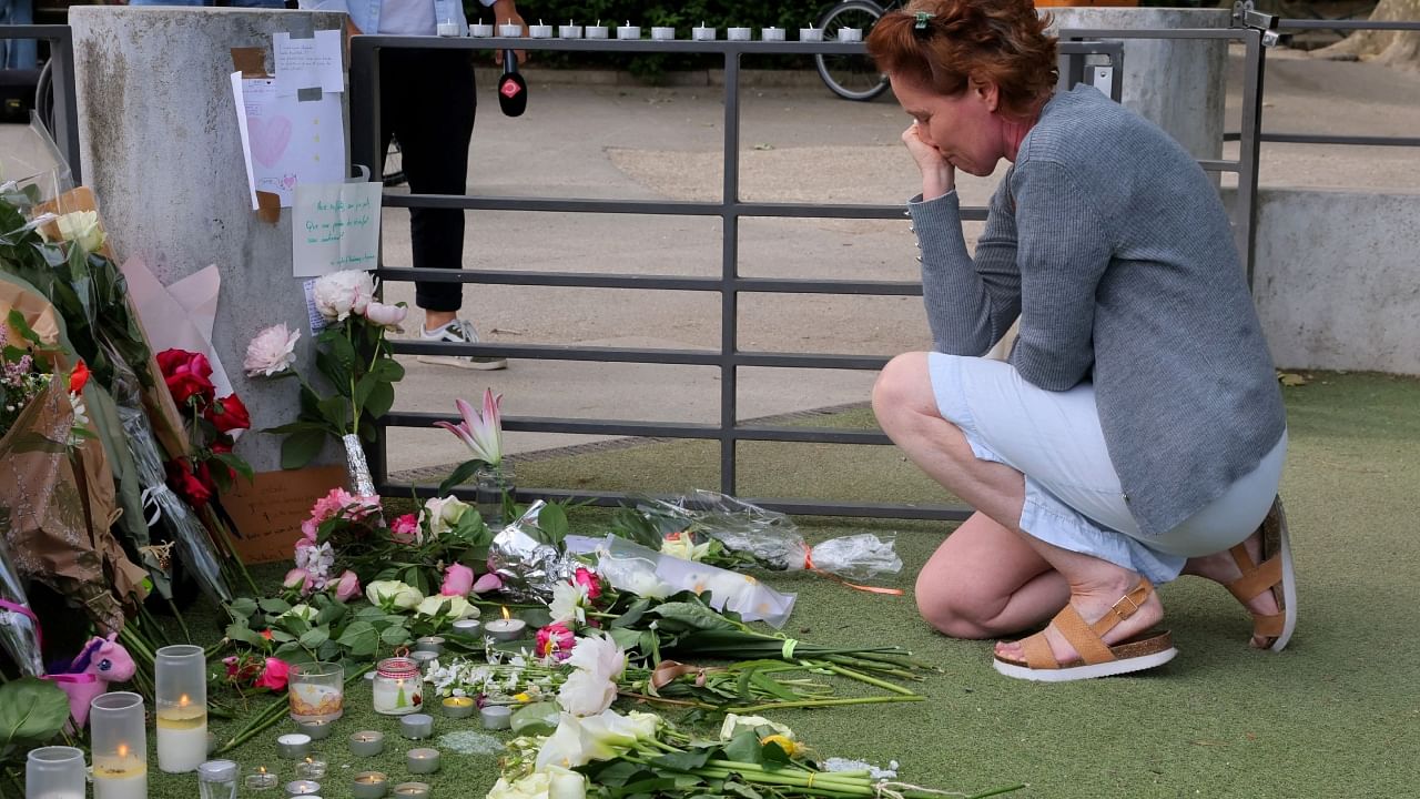 A woman pays respect in front of messages and floral tributes at the children's playground the day after several children and adults were injured in a knife attack at the Le Paquier park near the lake in Annecy, in the French Alps, France, June 9, 2023. Credit: Reuters Photo