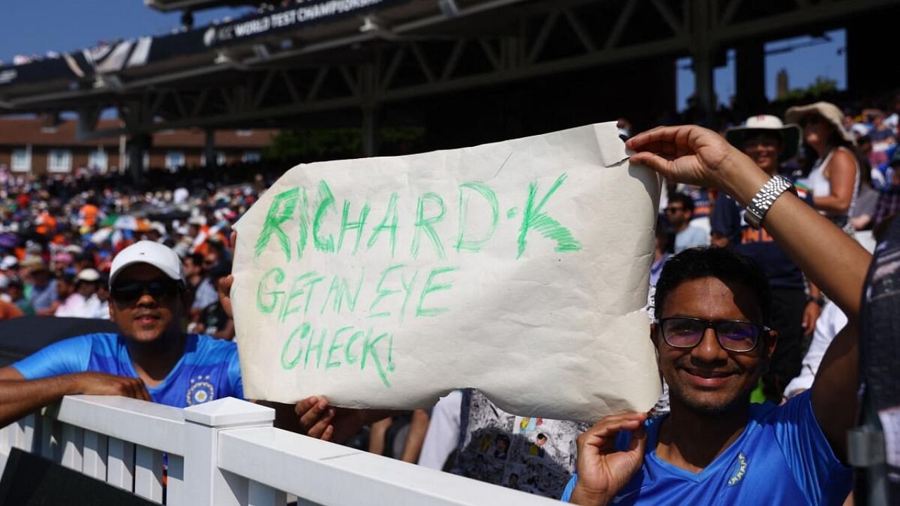India fans display a banner in reference to the television umpire, Richard Kettleborough after a decision to allow the dismissal of India's Shubman Gill from a catch by Australia's Cameron Green. Credit: Reuters Photo