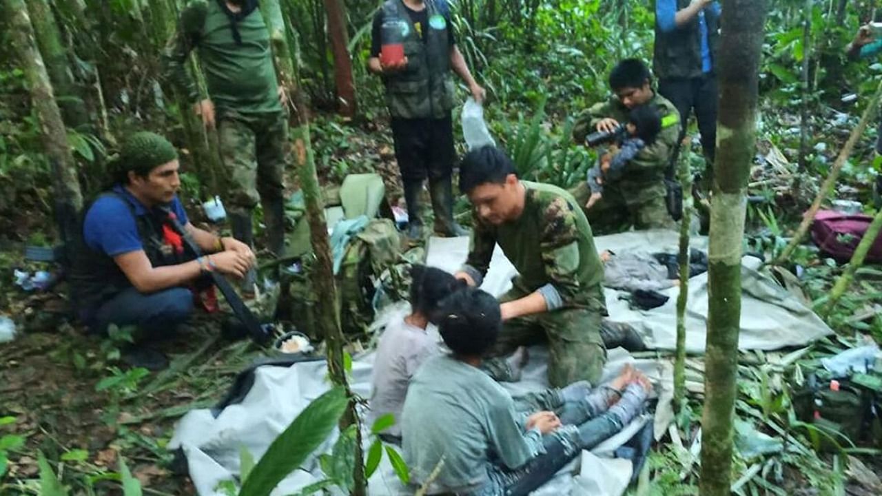 Colombian military soldiers attend to child survivors from a Cessna 206 plane that crashed last month. Credit: Reuters Photo