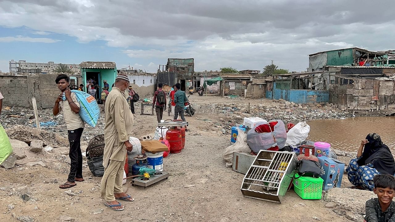 Villagers wait for transport for evacuation at Jakhau village ahead of Cyclone Biparjoy’s landfall, in Kutch district. Credit: PTI Photo