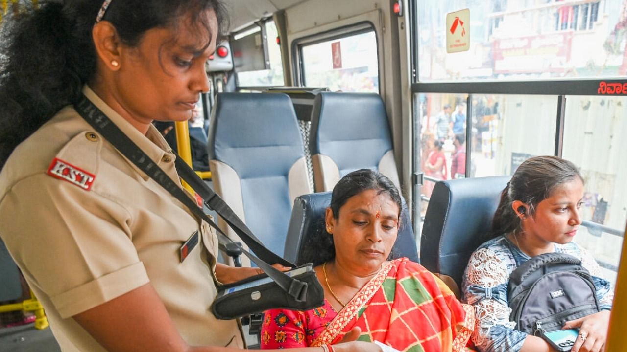 A bus conductor issues tickets to women passengers at Nagavara on Monday. DH Photo/S K Dinesh