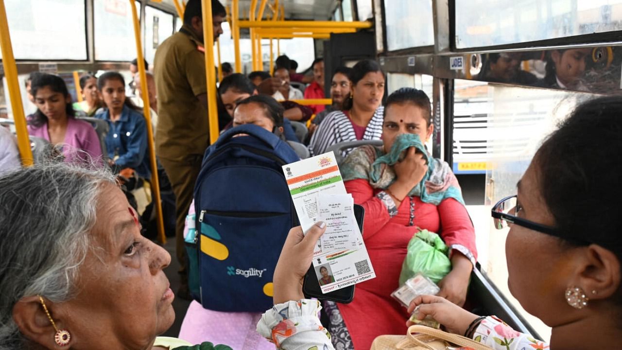 A woman display free ticket while boarding on BMTC bus at Majestic in Bengaluru. credit: DH Photo