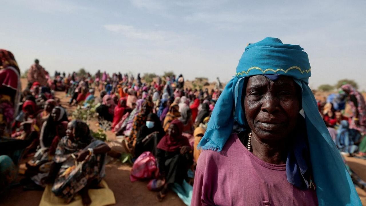  Halime Adam Moussa, a Sudanese refugee who is seeking refuge in Chad for a second time, waits with other refugees to receive a food portion from World Food Programme (WFP), near the border between Sudan and Chad in Koufroun, Chad, May 9, 2023. Credit: Reuters Photo