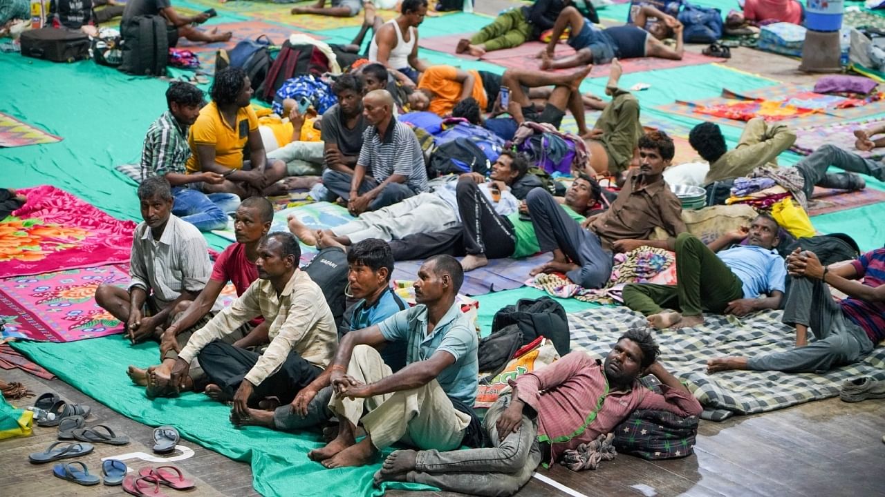 People evacuated from Kandla port taking shelter inside a multipurpose hall ahead of the landfall of Cyclone Biparjoy. Credit: Reuters Photo