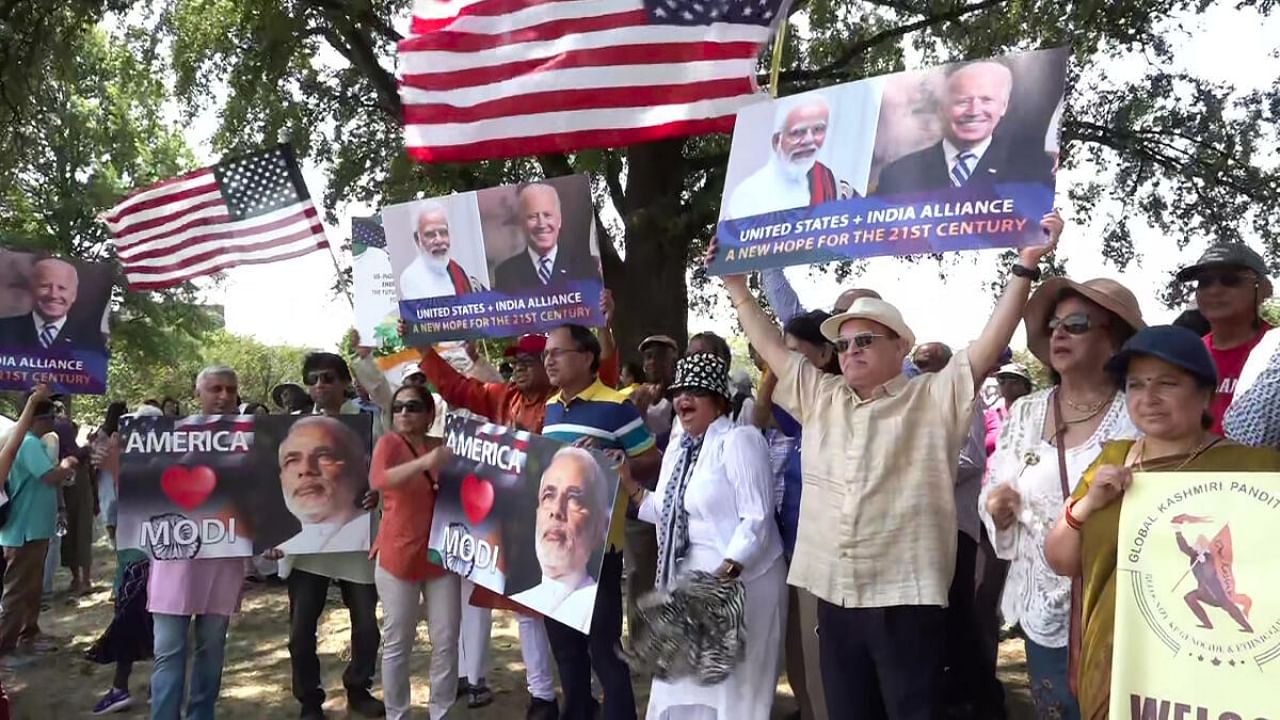 Indian community members hold posters of Prime Minister Narendra Modi and US President Joe Biden while raising patriotic slogans ahead of PM's state visit, in Washington. Credit: PTI Photo