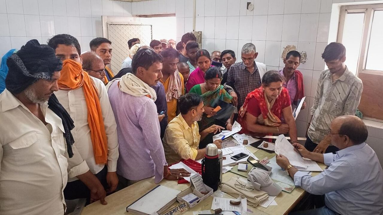 Family members of patients speaks with a health official at a hospital after several people were hospitalized due to heatwave conditions in UP's Ballia. Credit: PTI Photo