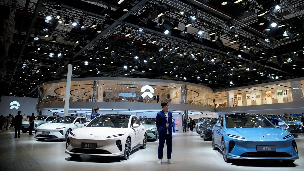  A staff member stands near Nio ET5 cars at its booth at the Auto Shanghai show, in Shanghai, China, April 18, 2023. Credit: Reuters Photo