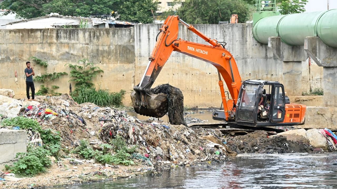 BBMP workers desilt rajakaluves (stormwater drains) near Jnanabharathi on Mysuru Road on Monday. Credit: DH Photo/Prashanth H G