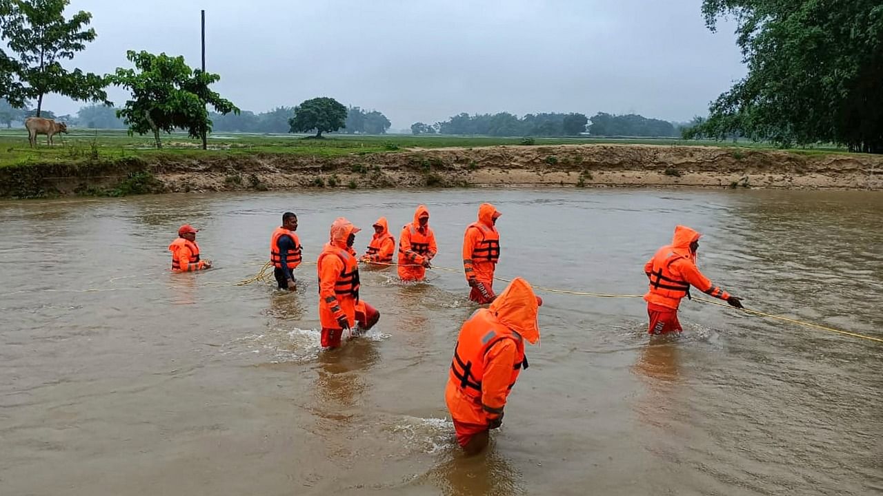 NDRF personnel carry out a search operation in Depota river after a local youth went missing in the flood-affected area of Bahbari near Tezpur, in Sonitpur district of Assam. Credit: PTI Photo