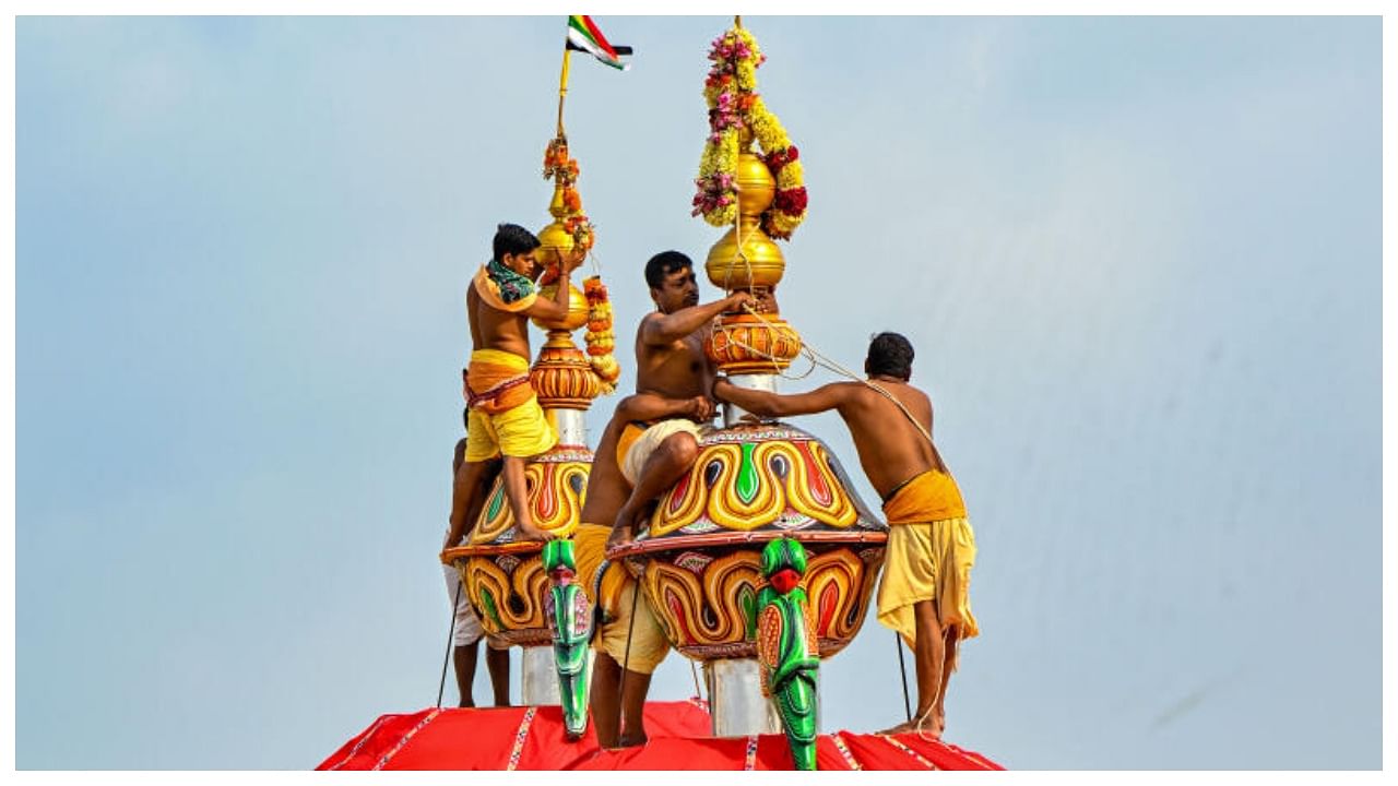 Priests put flags atop the chariots during 'Ratha Pratistha' ritual on the occasion of Rath Yatra festival, in Puri, Tuesday, June 20, 2023. Credit: PTI Photo