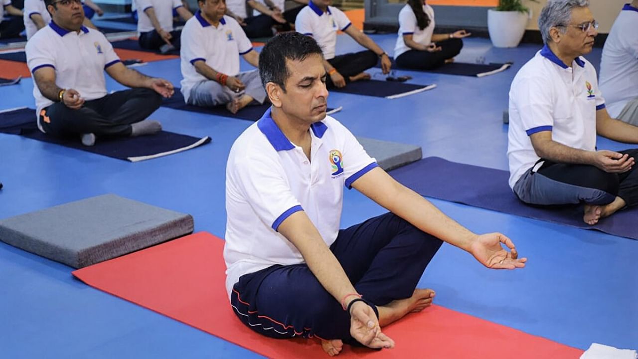 Chief Justice of India (CJI) DY Chandrachud with others performs yoga during a session on the International Yoga Day. Credit: PTI Photo