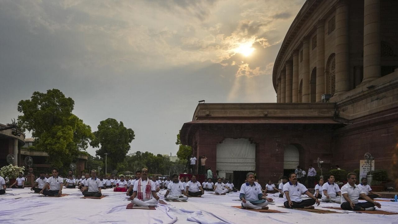 Lok Sabha Speaker Om Birla with Lok Sabha and Rajya Sabha officials performs yoga during a session on the International Day of Yoga, at the Parliament House complex in New Delhi, Wednesday, June 21, 2023. Credit: PTI Photo