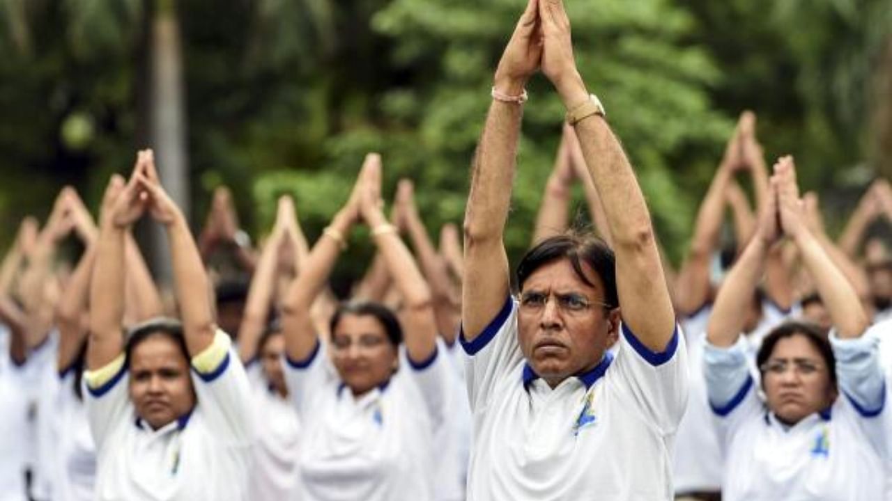 Union Minister for Health and Family Welfare Mansukh Mandaviya with others performs yoga on the International Day of Yoga. Credit: PTI Photo