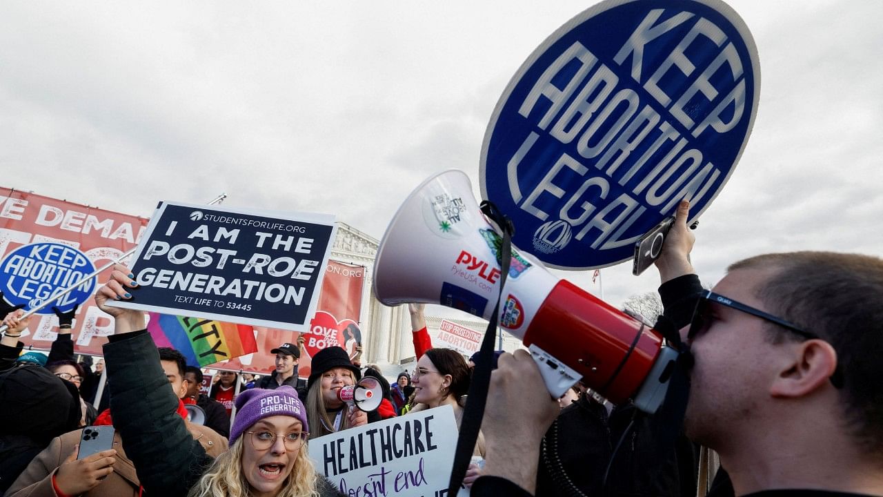 Abortion rights campaigners and anti-abortion demonstrators hold signs. Credit: Reuters File Photo