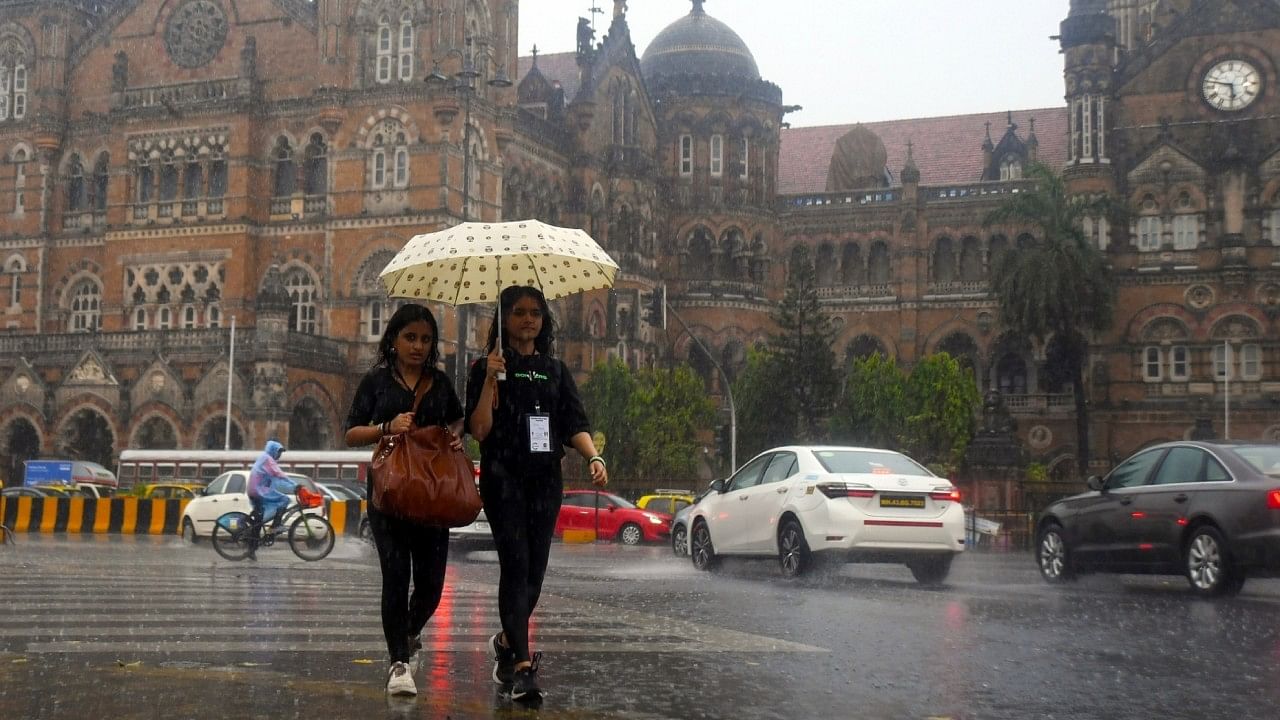 Women hold an umbrella as they walk on the street amid heavy rain in Mumbai. Credit: IANS Photo