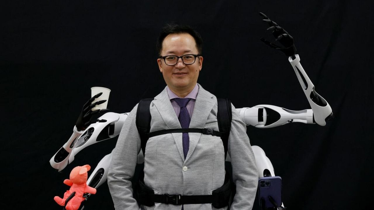 Masahiko Inami of the University of Tokyo poses with the wearable "Jizai Arms" robot arms at his lab during its demonstration in Tokyo. Credit: Reuters Photo