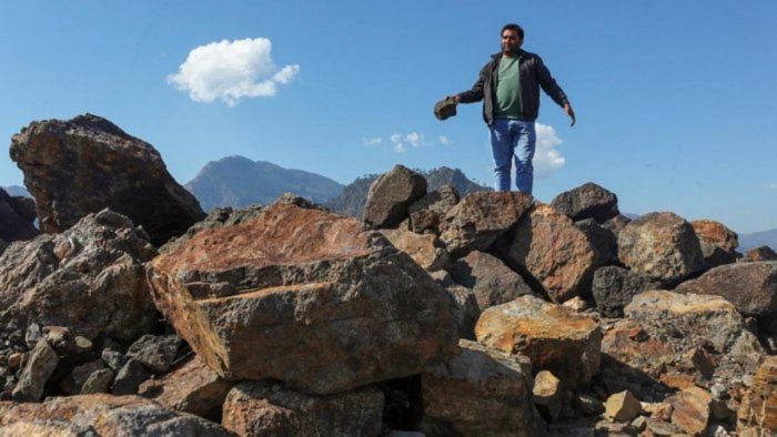 <div class="paragraphs"><p>A villager poses with lithium stones in Jammu's Reasi district. </p></div>