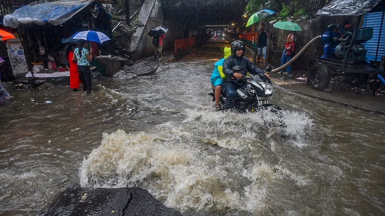 Commuters on a waterlogged road amid rain in Mumbai. Credit: PTI Photo