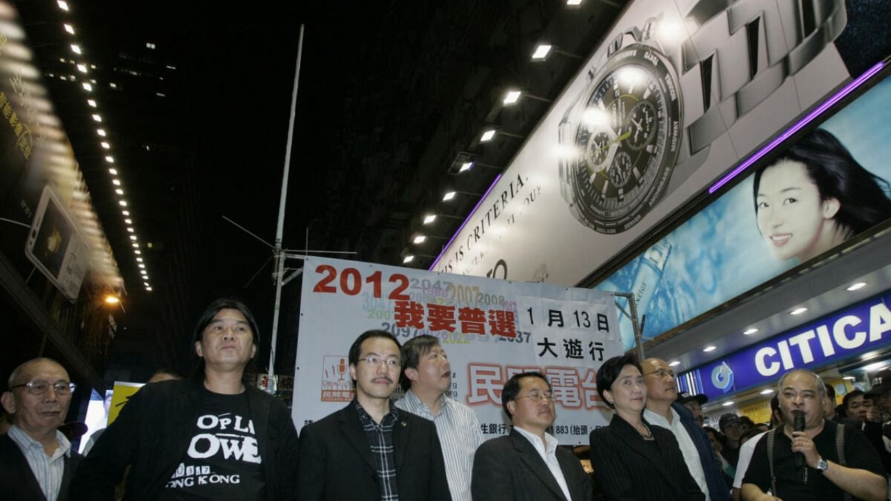 An antenna is set up on a street in Hong Kong's Mongkok shopping district as pro-democracy activists Leung Kwok-hung (2nd L) and Tsang Kin-shing (R), a host at Citizens' Radio, along with pro-democracy lawmakers Emily Lau (3rd R) and Lee Wing-tat (4th R), take part in a broadcast despite a government warning January 10, 2008. The banner at the back reads, "I need universal suffrage." Credit: Reuters Photo