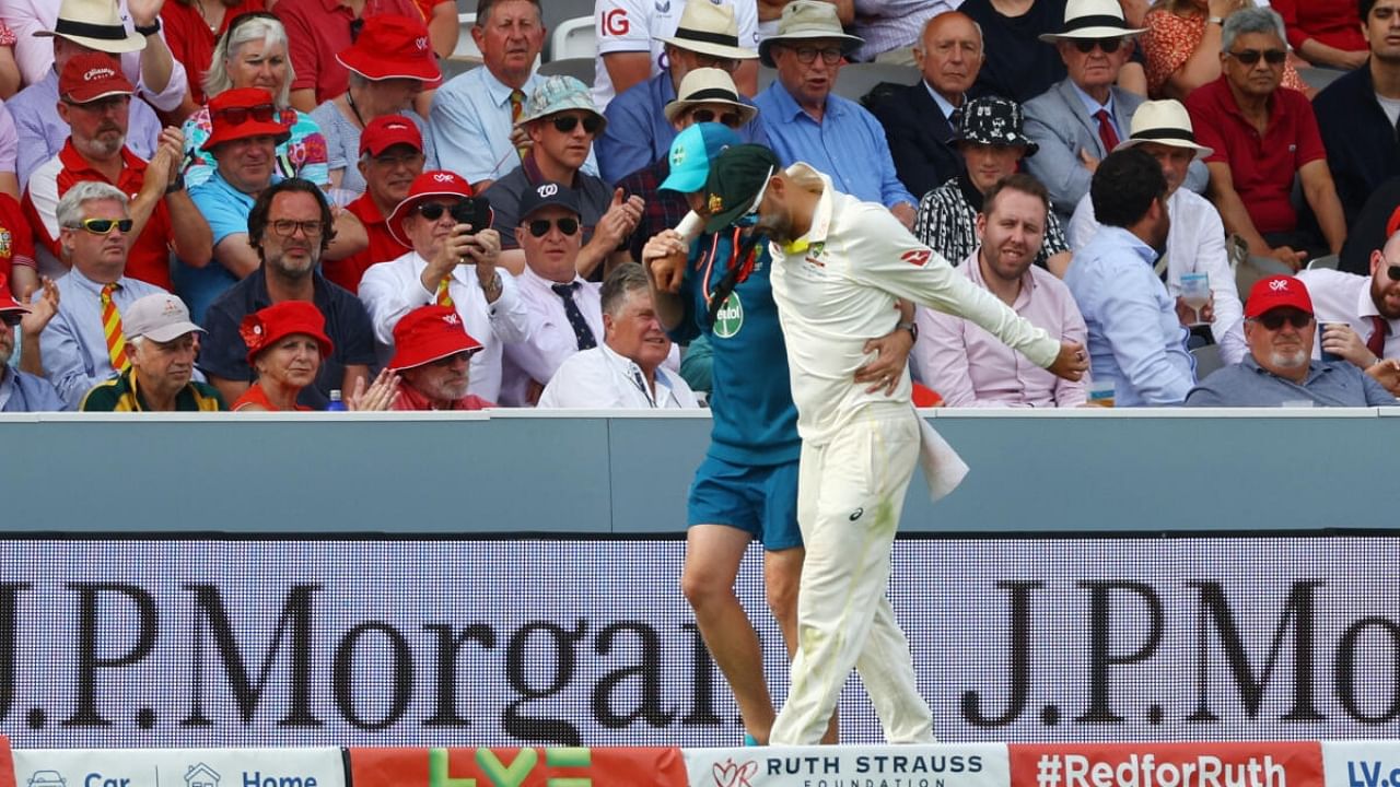 Australia's Nathan Lyon is helped around the field after sustaining an injury. Credit: Reuters Photo