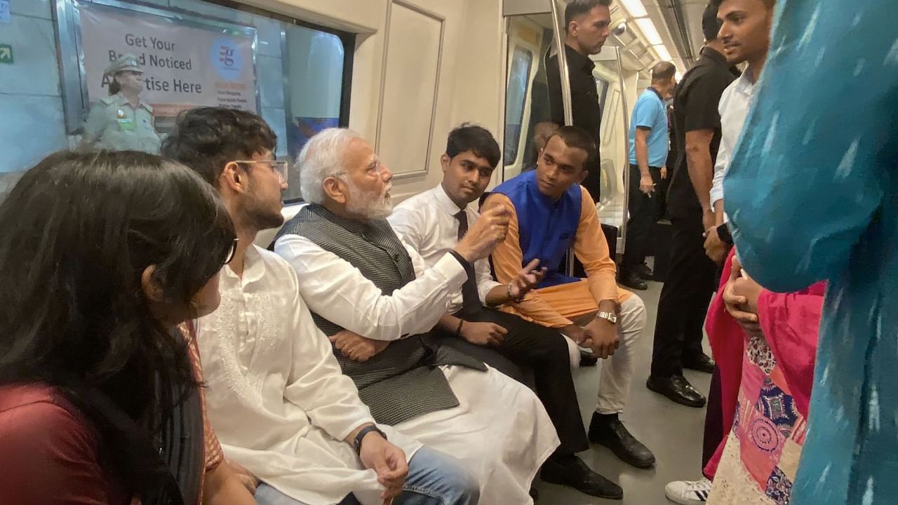 Prime Minister Narendra Modi interacts with passengers as he travels in Delhi Metro to reach Delhi University to attend its centenary celebrations. Credit: PTI Photo