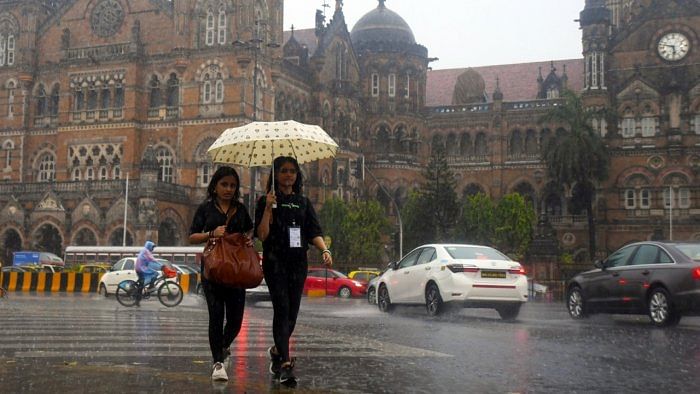 Women hold an umbrella as they walk on the street amid heavy rain in Mumbai. Credit: IANS File Photo  