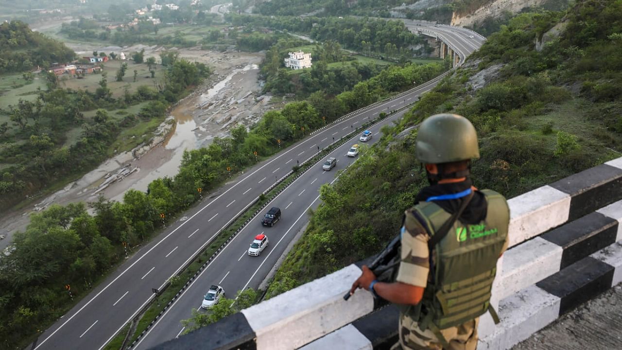 A security personnel keeps vigil as a convoy of second batch of Amarnath Yatra 2023 pilgrims leaves for Kashmir, in Jammu, Saturday, July 1, 2023. Credit: PTI Photo