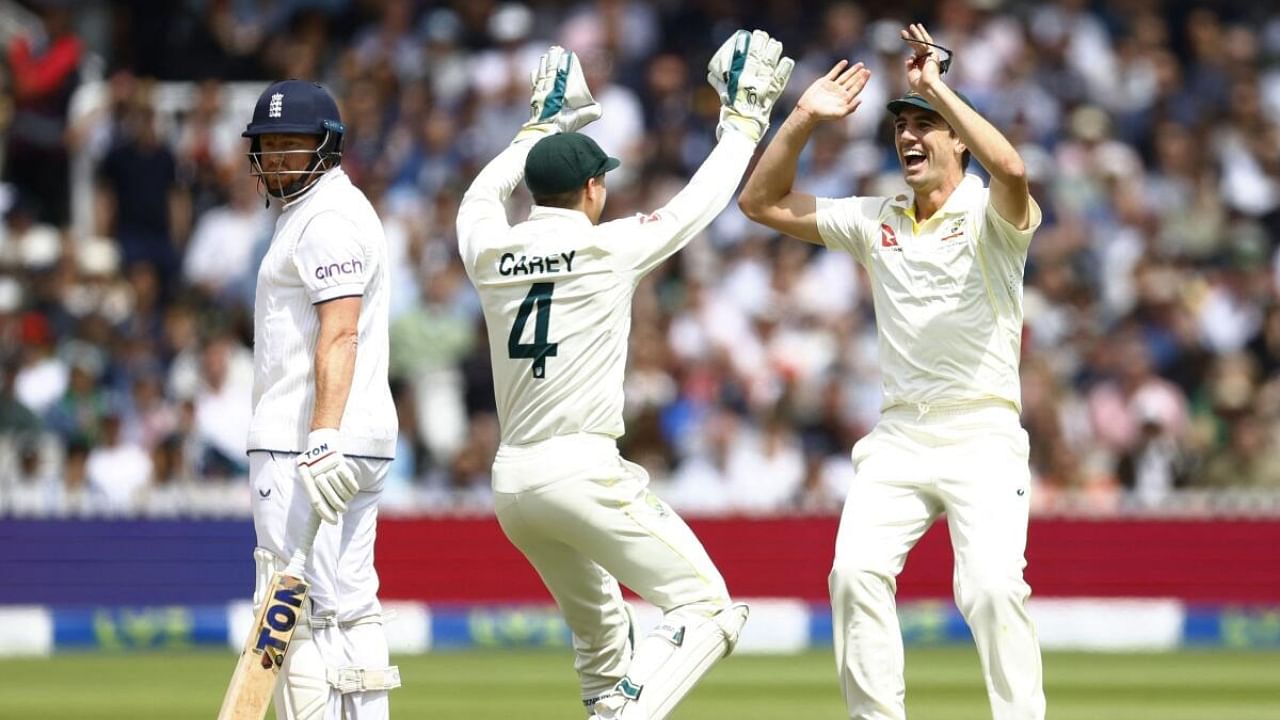 Australia's Alex Carey celebrates with Pat Cummins after running out England's Jonny Bairstow. Credit: Reuters Photo