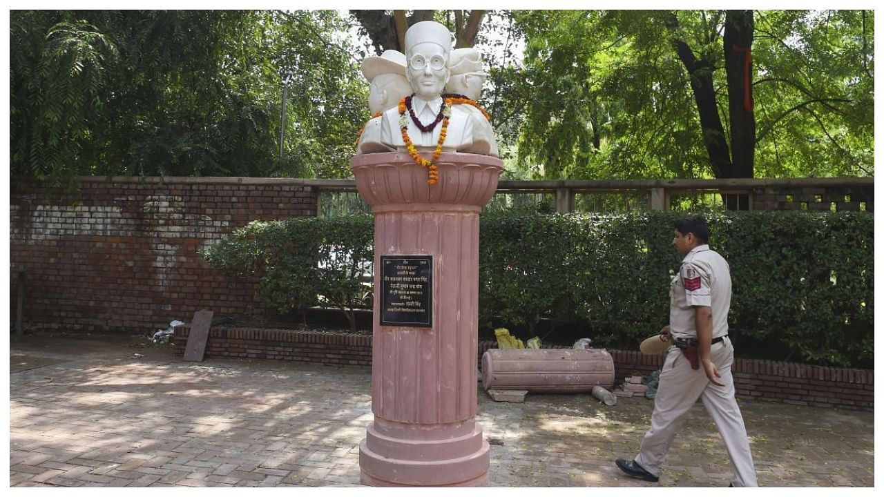 A policeman walks past the busts of Veer Savarkar, Subhash Chandra Bose and Bhagat Singh installed outside the Arts Faculty of Delhi University, in New Delhi. Credit: PTI Photo