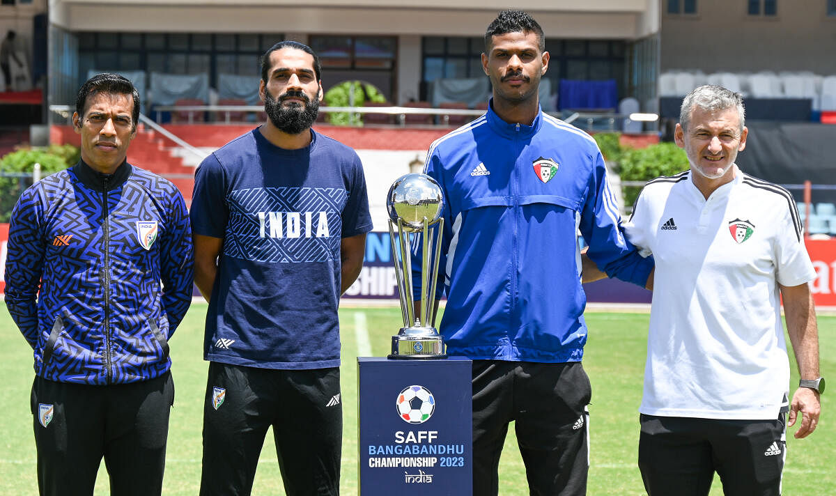 (From left) Indian team's assistant coach Mahesh Gawli, Sandesh Jhingan, Kuwait's Bader Bin Saanoun and coach Rui Bento are seen with the SAFF Championship trophy ahead of their final at the Sree Kanteerava Stadium in Bengaluru on Monday. DH Photo/ B H Sh