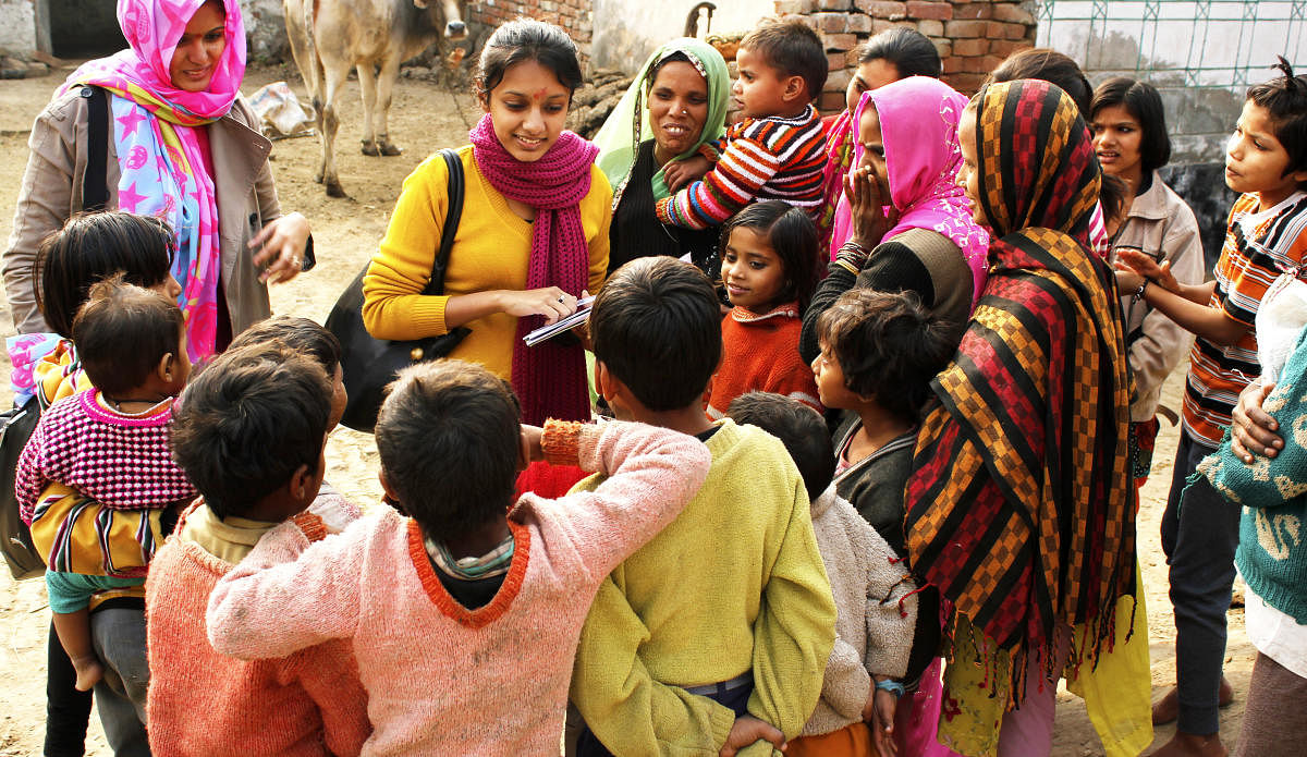 Ghaziabad, Uttar Pradesh, India- December 23, 2013: Two female social workers are interacting with a group of villagers comprising of children and female adults. They are working for the development of the village and uplifting the standard of living in t